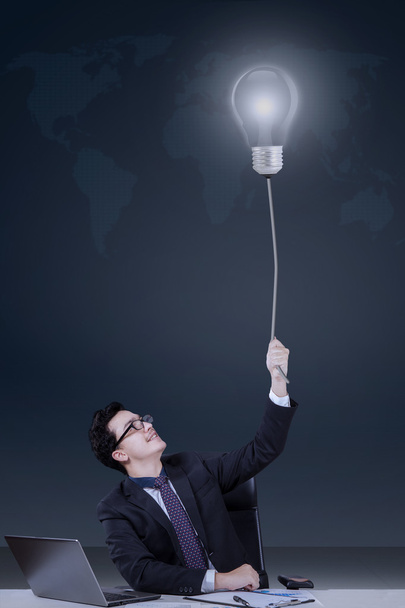 Jovem gerente caucasiano puxando lâmpada
 - Foto, Imagem