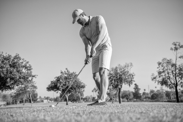 golfer in cap with golf club. people lifestyle. unshaven man playing game on green grass. summer activity. professional sport outdoor. male golf player on professional golf course. - Fotoğraf, Görsel