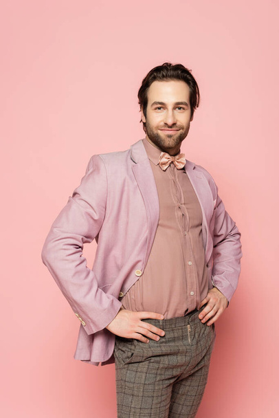 Trendy host of event posing and looking at camera on pink background  - 写真・画像