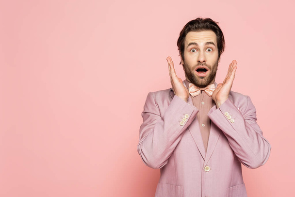 Shocked host of event looking at camera on pink background  - Photo, Image