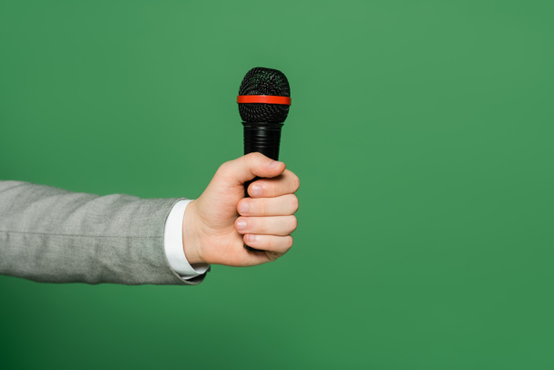 levágott nézet újságíró kezében mikrofon a kezében elszigetelt zöld  - Fotó, kép