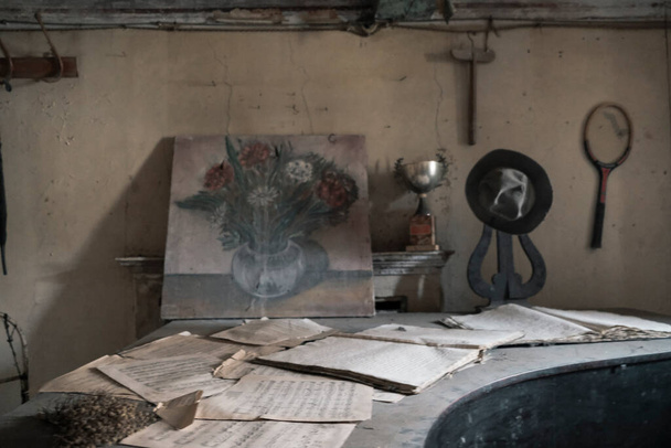  in the abandoned housedesk with sheets and picture in abandoned house. High quality photo - Fotó, kép