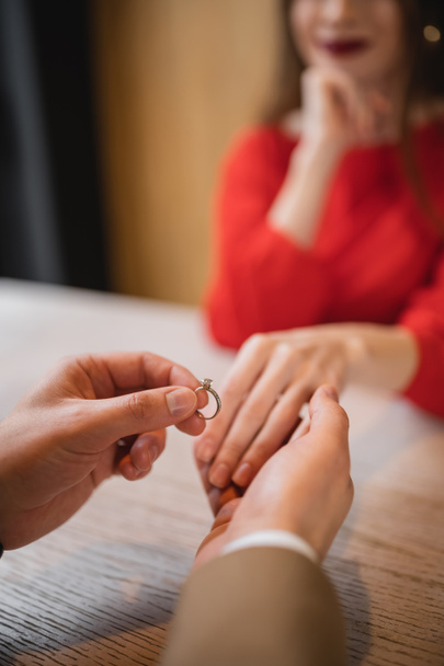 ostříhaný pohled na muže držícího zásnubní prsten a ruku přítelkyně na Valentýna  - Fotografie, Obrázek