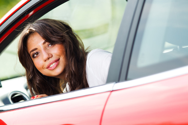 Young pretty woman looking at back of car - Фото, изображение