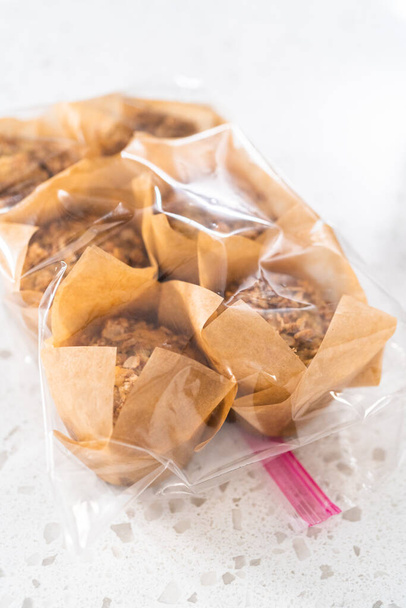 Zubereitung der Mahlzeiten. Verpackung von Bananen-Haferflocken-Muffins in den Kunststoff zurück zur Aufbewahrung im Gefrierschrank. - Foto, Bild