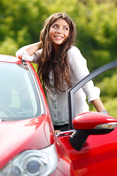 Young pretty woman in the red car - 写真・画像