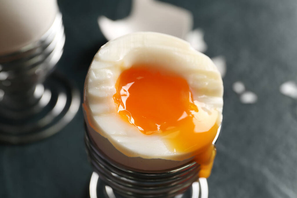 Soporte con huevos cocidos sobre fondo negro - Foto, imagen