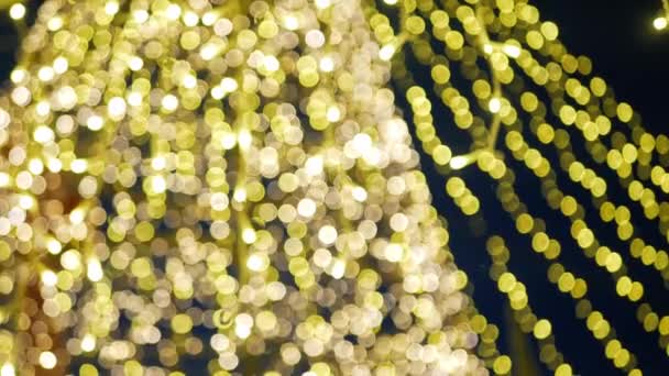 Yılbaşı kutlamalarında aydınlatma dekorasyonunu aydınlatan şenlik ışığının odak noktasından, arka plan şenlik kavramını bulanıklaştıran - Video, Çekim