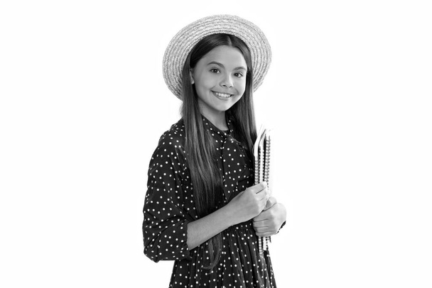 smiling child in straw hat hold school copybook for studying isolated on white, childhood. - Photo, Image