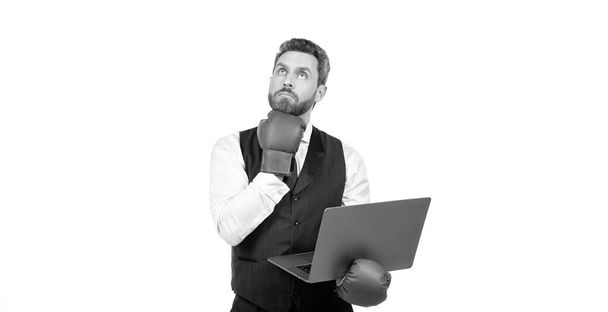 réfléchissant homme en gants de boxe et costume tenir ordinateur portable isolé sur fond blanc, méditer. - Photo, image