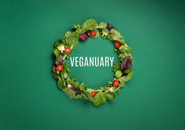Vegetarische en veganistische dieet maand in januari genaamd Veganuary. Verscheidenheid van veganistisch, plantaardige eiwitvoedsel, gezonde rauwe groenten. Bovenaanzicht op groene achtergrond. - Foto, afbeelding