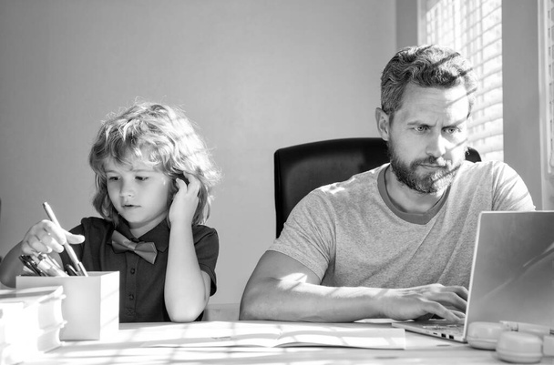 mature homme professeur ou papa aider enfant fils avec école devoirs sur ordinateur, à la maison. - Photo, image