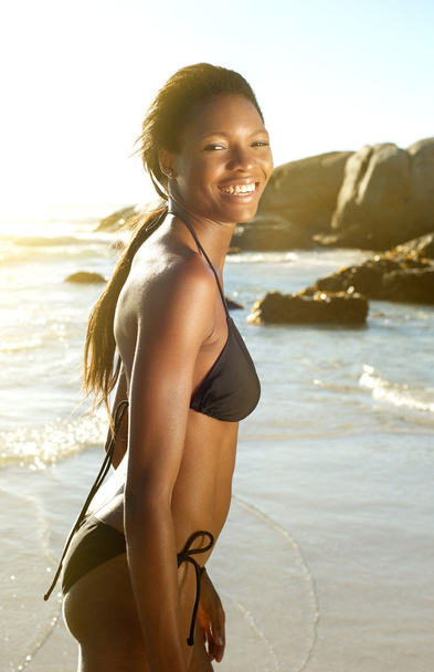 Donna afroamericana in bikini sorridente in spiaggia
 - Foto, immagini