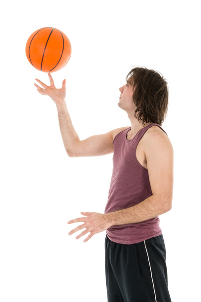 Young man with spinning basketball at his forefinger - Φωτογραφία, εικόνα
