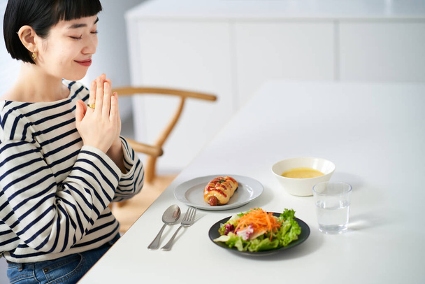 Woman starting a meal in the dining room at home - Photo, Image