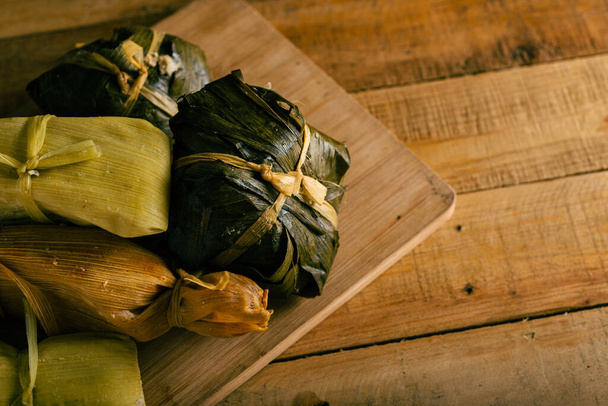 Tamales, comida típica mexicana hecha de maíz sobre una mesa de madera. - Foto, imagen