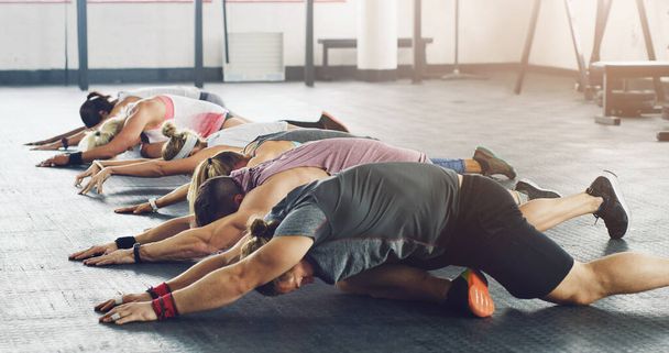 Pokloňte se před bohy fitness ve cvičebním chrámu. skupina mladých lidí, kteří spolu pracují v tělocvičně - Fotografie, Obrázek