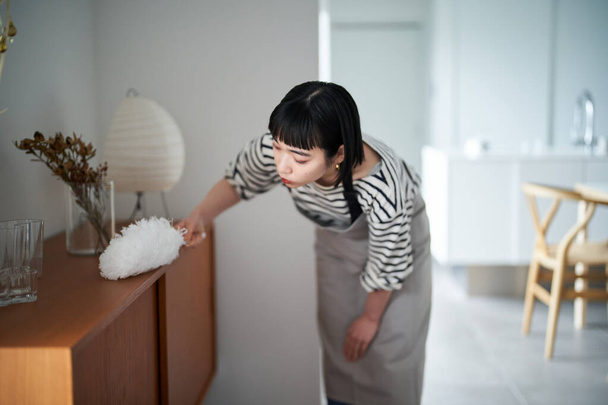 Ασιάτισσα νεαρή γυναίκα καθαρίζει το δωμάτιο - Φωτογραφία, εικόνα