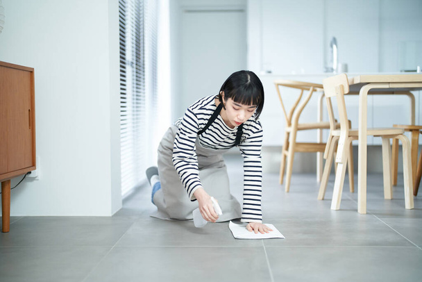 mladá žena tření podlahu v místnosti - Fotografie, Obrázek