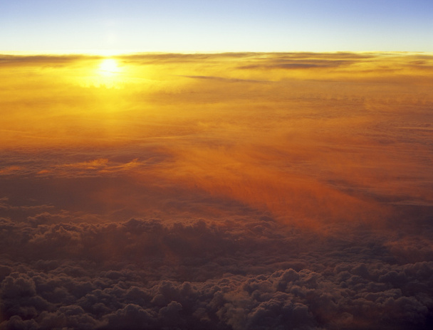 Zonsondergang over een wolken. - Foto, afbeelding