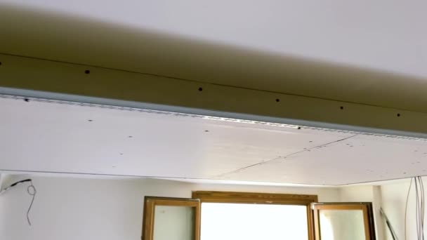 Gipsplaat sluier bevestigd aan het plafond. Structuur voor het hosten van ledstrips voor kamerverlichting. - Video