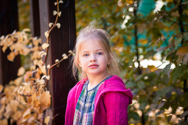 Улыбающаяся смешная маленькая девочка в яркой одежде
 - Фото, изображение