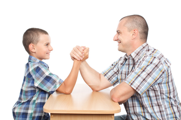 Father and son having fun with arm wrestling - Foto, Imagen