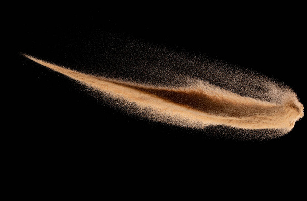 Μικρό μέγεθος λεπτής άμμου που πετά έκρηξη, χρυσό κύμα κόκκων εκραγεί. Αφηρημένη πτήση σύννεφο. Κίτρινη χρωματιστή άμμος βουτιά πυριτία στον αέρα, κομήτης ουρά πάγου πέσει κάτω στη γη. Στοιχείο Μαύρο φόντο απομονωμένο - Φωτογραφία, εικόνα