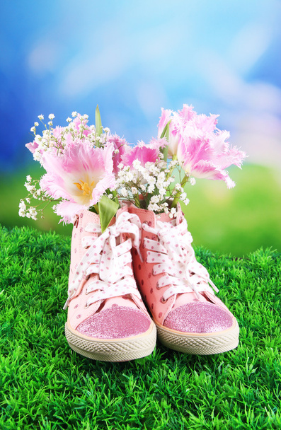 Beautiful gumshoes with flowers inside on green grass, on bright background - Foto, immagini