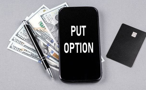 Кредитна картка і текст PUT OPTION на смартфоні з доларами і ручкою. Бізнес
 - Фото, зображення