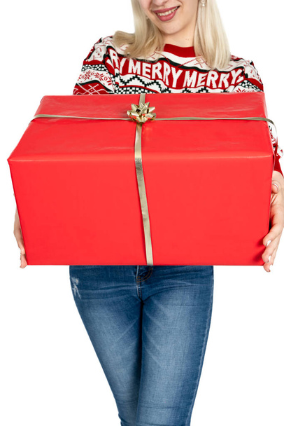 Неузнаваемая женщина Неузнаваемая женщина, предлагающая рождественский подарок. Неузнаваемая женщина, одетая в рождественскую одежду и предлагающая и рекламирующая рождественский подарок. Студия на белом фоне - Фото, изображение