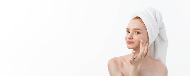 krásný model použití kosmetika krém na obličej na bílém - Fotografie, Obrázek