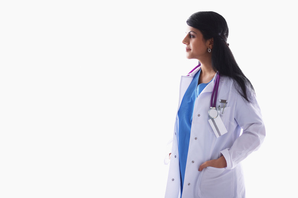 Orvos nő sztetoszkóppal áll a fal mellett - Fotó, kép