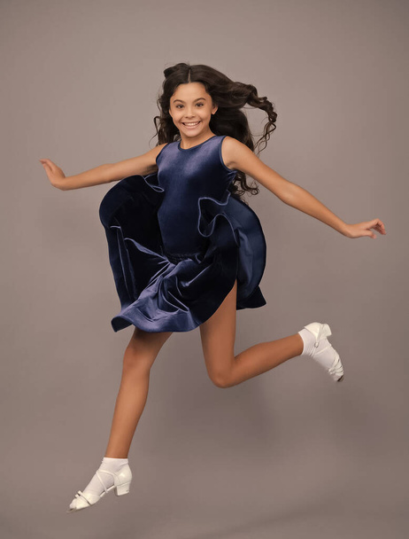 Full length teenager with movement dress. Young teen child with flowing skirt. Teen girl fluttering dress in motion, isolated on gray - Fotoğraf, Görsel