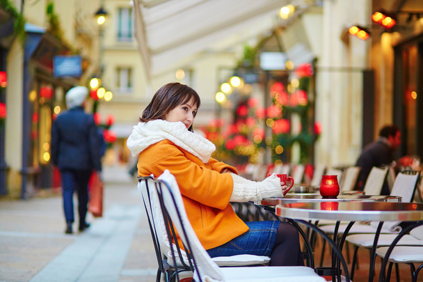 Happy girl drinking coffee in a Parisian cafe - Fotografie, Obrázek