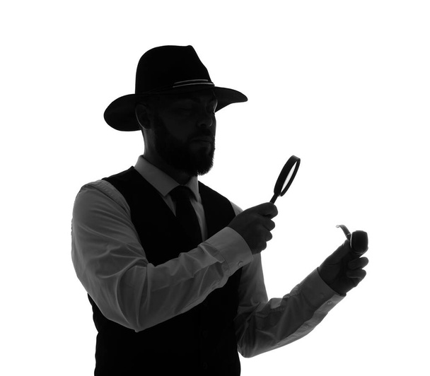 Силуэт детектива-мужчины с увеличителем и дымящейся трубкой на белом фоне - Фото, изображение