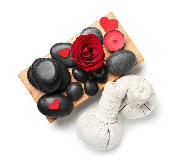 Gyönyörű spa kompozíció Valentin-napra rózsával, gyertyával, kövekkel és gyógynövényes zsákokkal fehér alapon - Fotó, kép