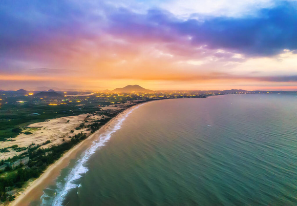 Letecký pohled na centrální pobřeží Vietnamu za úsvitu s pobřežím, modré vlny moře, východ slunce je místem pro víkendový odpočinek a rybaření místních rybářů - Fotografie, Obrázek