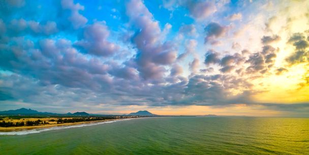 Vista aérea de la costa central de Vietnam al amanecer con la costa, olas azules del mar, salida del sol es un lugar para la relajación de fin de semana y la pesca de los pescadores locales - Foto, Imagen