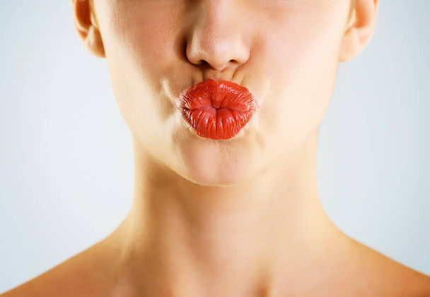 Lassen Sie Ihren Lippenstift sprechen. Ausgeschnittene Studioaufnahme einer schönen jungen Frau mit rotem Lippenstift und Schmollmund vor grauem Hintergrund - Foto, Bild