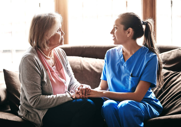 Sie haben eine besondere Verbindung. eine Krankenschwester hält eine ältere Frau in der Hand - Foto, Bild