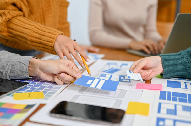 A team of professional mobile application designers are in the meeting, discussing and brainstorming user interface design. close-up image. UX UI concept - Photo, Image