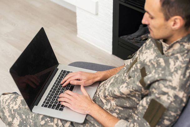 militaire en uniforme regardant ordinateur portable. - Photo, image