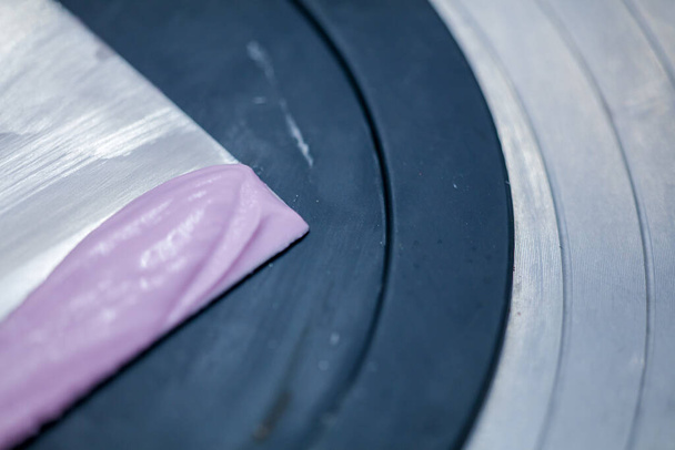 pasticciere utilizzando spatola raschietto per lilla crema di burro rosa torta glassata preparazione torta di compleanno - Foto, immagini