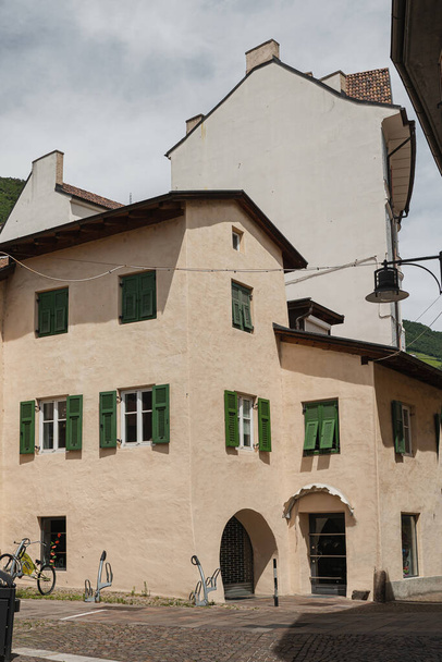 İtalya 'daki eski tarihi mimari. Geleneksel Avrupa eski kasaba binası. Ahşap pencereler, kepenkler ve güneş ışığı gölgeli renkli pastel duvarlar. Estetik yaz tatili seyahat geçmişi - Fotoğraf, Görsel