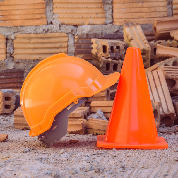 Bouw helm veiligheid en schuin uitlopend in bouwplaats - Foto, afbeelding