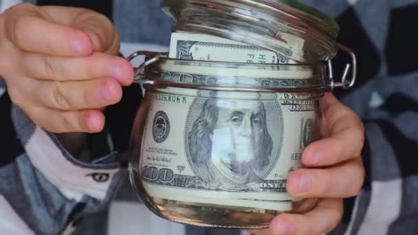 Dollar banknote saving money in glass jar. Unrecognizable woman moderate consumption and economy Collecting money. Tips. Business, finance, saving, banking and people concept. Extra money, passive - Filmagem, Vídeo