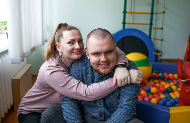 介護中の母親はリハビリテーションセンターで自閉症と診断された子供を抱き - 写真・画像