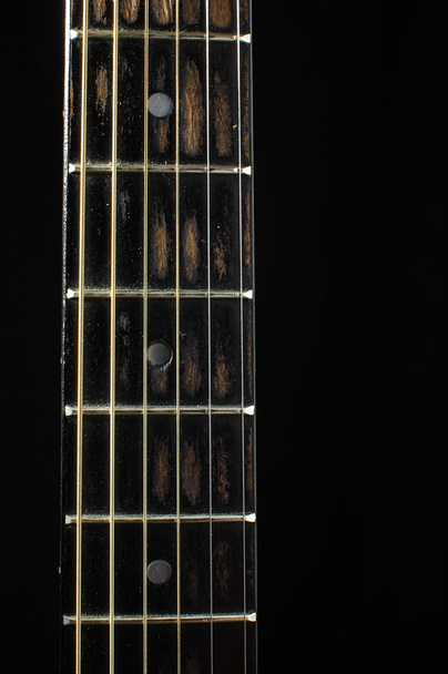 Acoustic guitar fretboard isolated on the dark background - Photo, Image