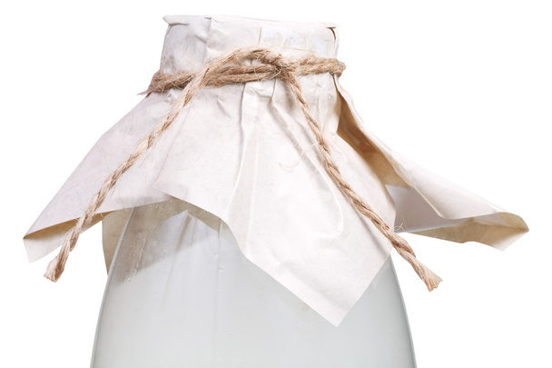 melk fles gesloten door bruine papieren - Foto, afbeelding